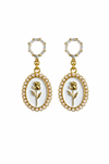 Pair of earrings with floral design and pearl accents on a white background