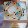 Set of beaded bracelets with turquoise and brown beads in a box held by a hand.