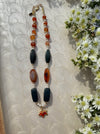 Necklace with multicolored beads on a textured surface with flowers