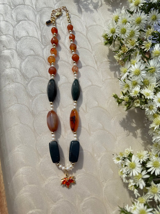 Necklace with multicolored beads on a textured surface with flowers