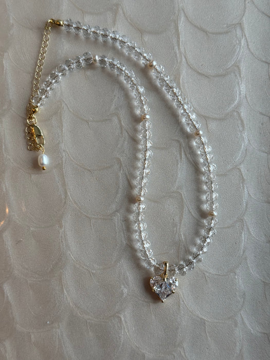 Necklace with heart-shaped pendant on a textured surface